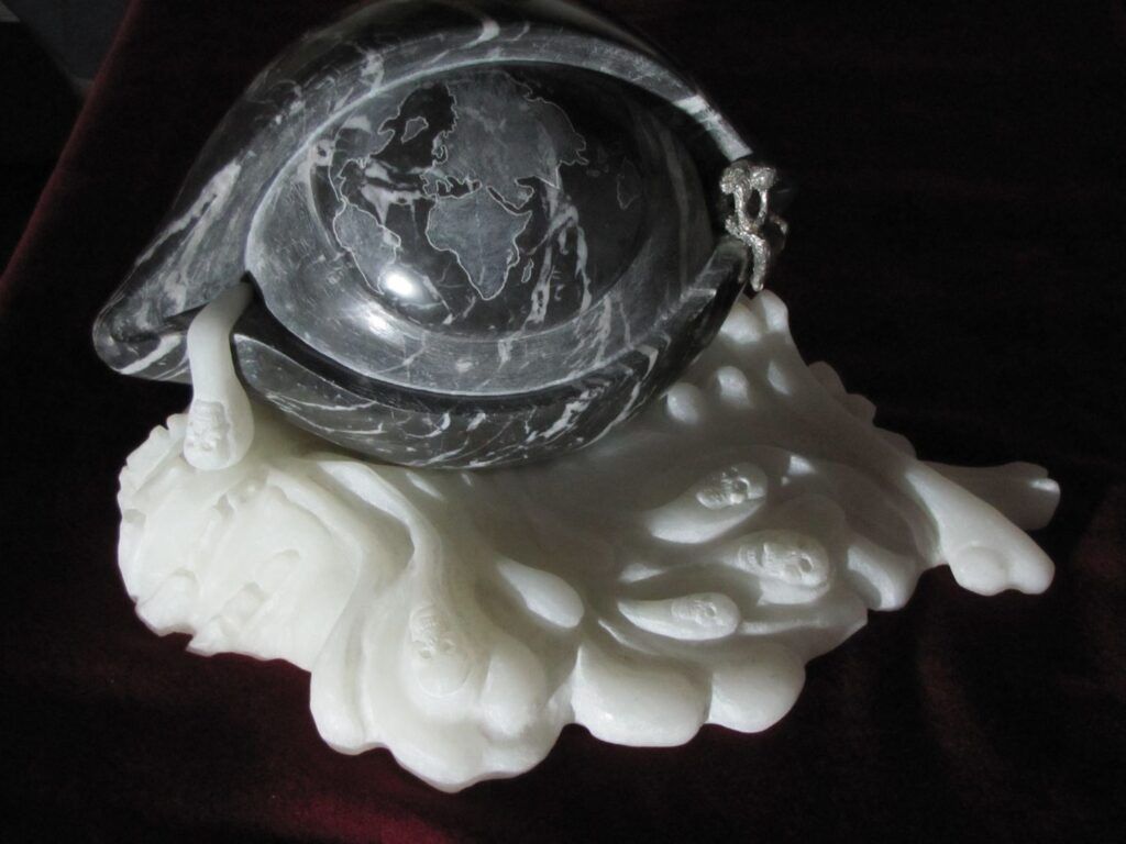 sculpture-L’œil (marbre Marquinia) dans  lequel se reflète un monde sombre, un flot de larme s’en écoule (onyx blanc). Un petit personnage réfléchit dans un coin.