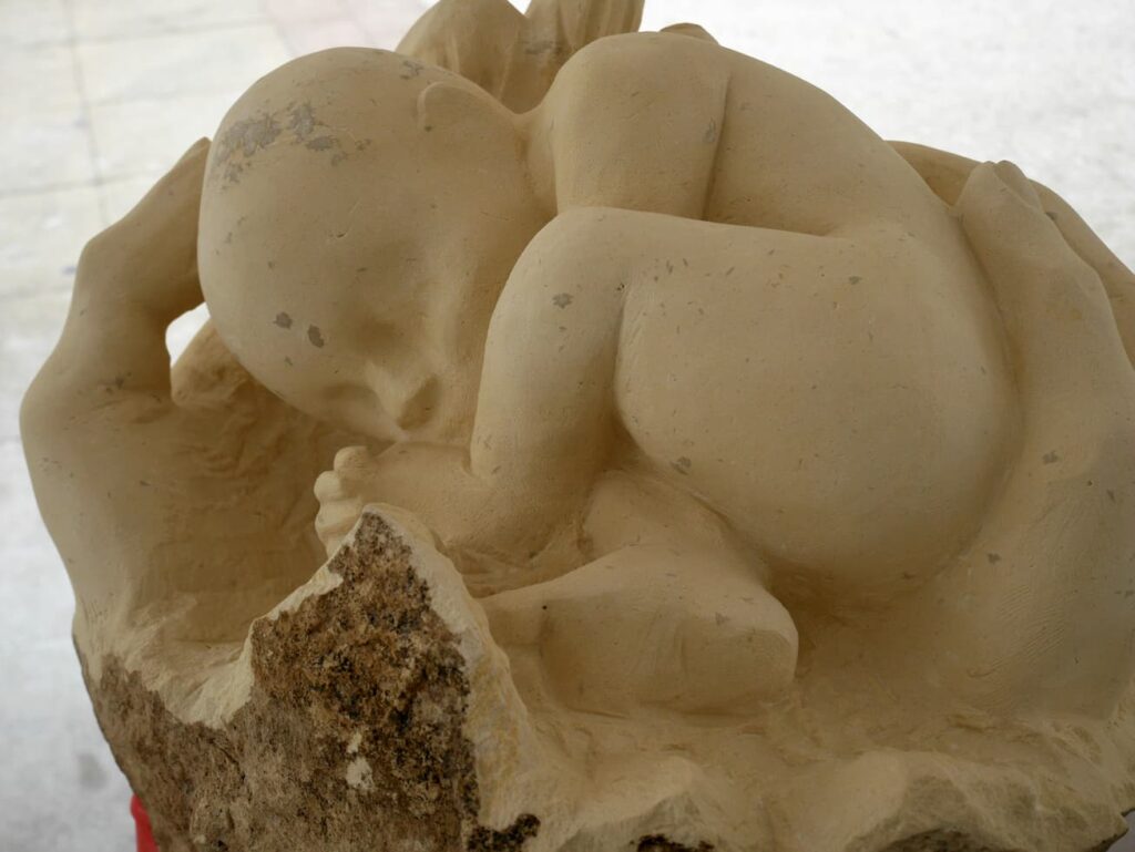 Sculpture Naissance-bébé sculpté dans une main sculptée vue de haut-Rapha