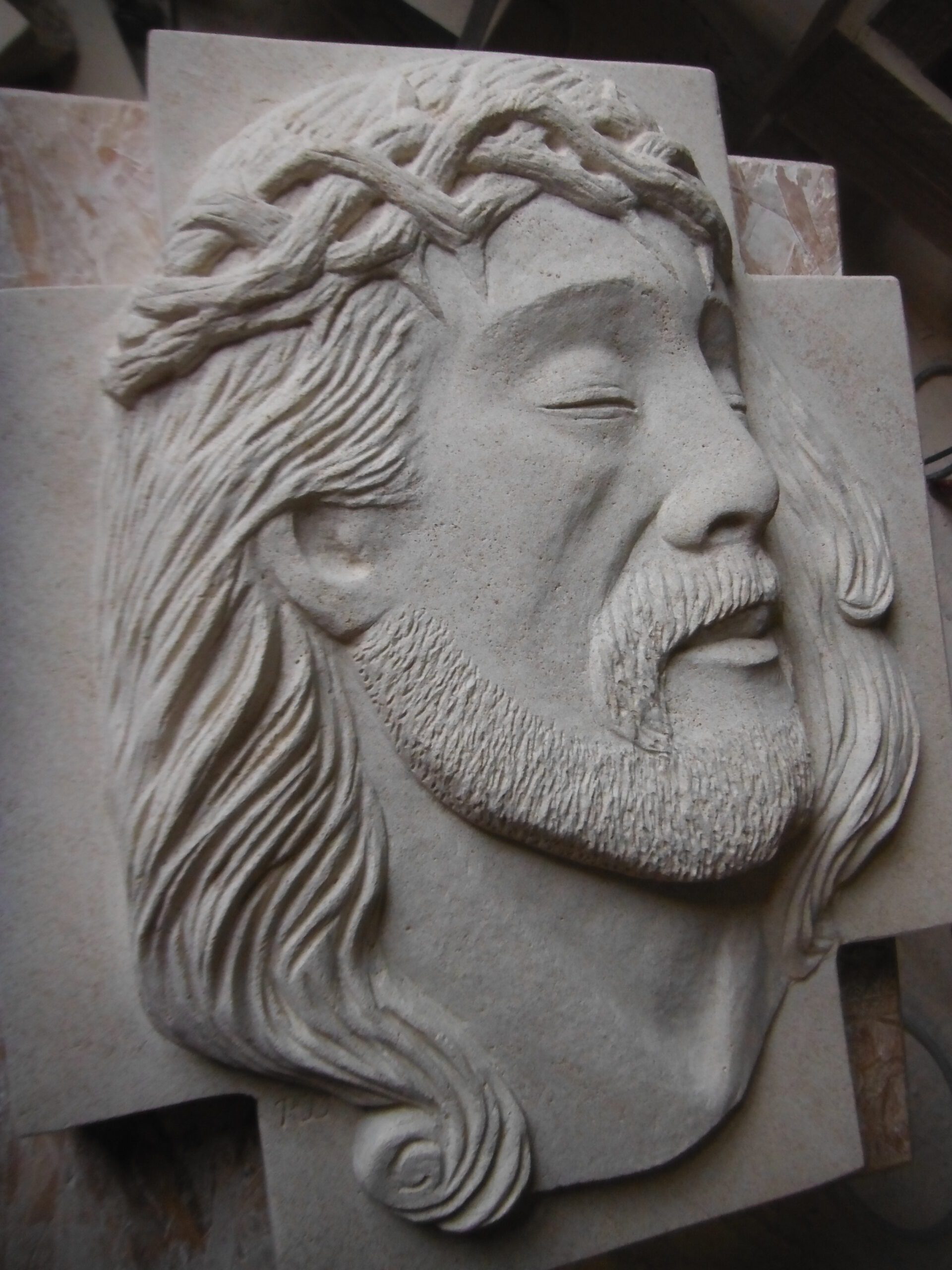 Sculpture Christ en bas relief sur croix en pierre de Frontenac.
