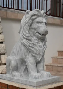 Sculpture en marbre de Carrare représentant un lion de profil gauche, réalisée par Raphaëlle Duval à Bassens, dimensions 80×70×40 cm.