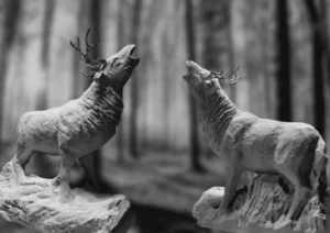 Image de deux sculptures en pierre calcaire de Thenac et etain representant deux cerfs bramant face a face, realisees par l’artiste Raphaelle Duval.