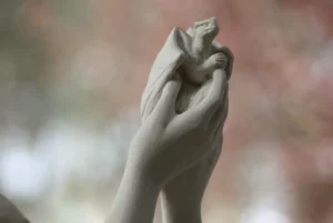 Sculpture d’un bébé dragon tenu dans les mains d’une femme, création de Raphaelle Duval à Bassens 33530