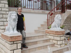 L'artiste Raphaëlle Duval est entourée de deux sculptures de lions en marbre de Carrare, dimensions 80h x 70 x 40 cm.