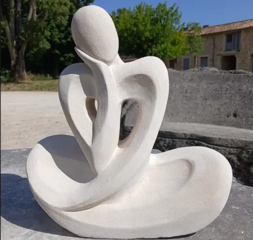 Sculpture en pierre stylisée représentant une silhouette assise en position méditative, réalisée par les élèves des Ateliers Raphaëlle à Bassens (33530)