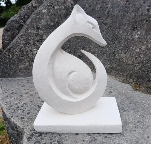 Sculpture en pierre représentant un renard lové en spirale sur socle, réalisée par les élèves des Ateliers Raphaëlle à Bassens (33530)