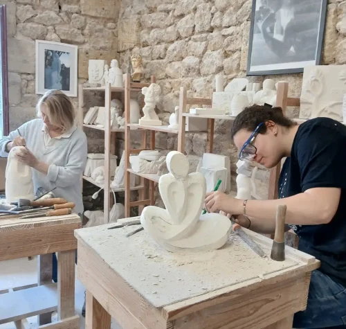 Élèves des Ateliers Raphaëlle sculptant la pierre à l'établi, atelier de sculpture de Bassens (33530)