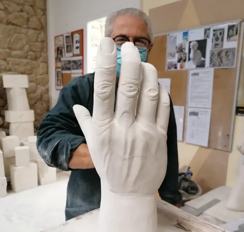 Élève des Ateliers Raphaëlle présentant une sculpture en pierre d'une main grandeur nature, atelier de Bassens (33530)