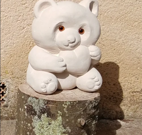 Sculpture en pierre représentant un ourson attendrissant tenant un cœur, réalisée par les élèves des Ateliers Raphaëlle à Bassens (33530)